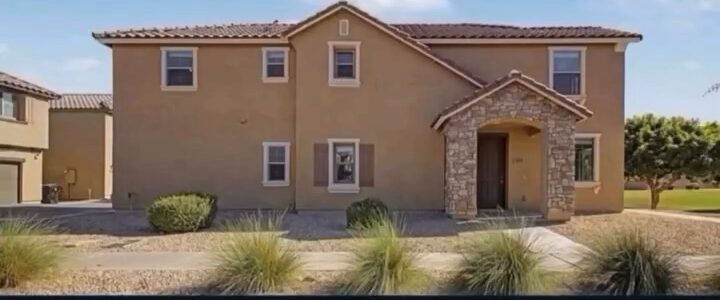 Two-story stucco home with a stone entry