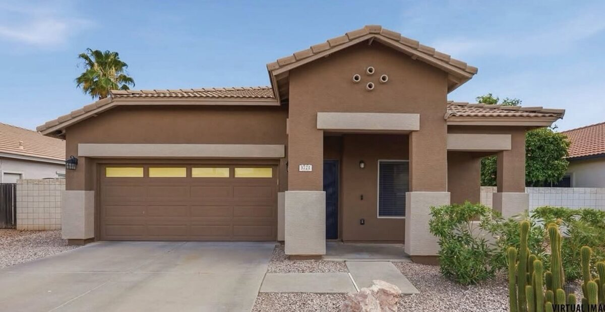 Single-story home with a two-car garage and a saguaro by the walk